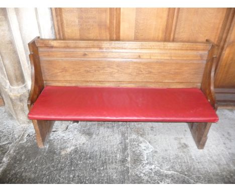 A oak pew with single panelled back and prayer book shelf to the reverse, 134cm wide, 40cm deep, 81cm high Please Note this L