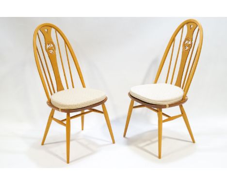 A pair of Ercol bent beech wood and elm Windsor style dining chairs, the central splats pierced with a swan motif, 100cm high