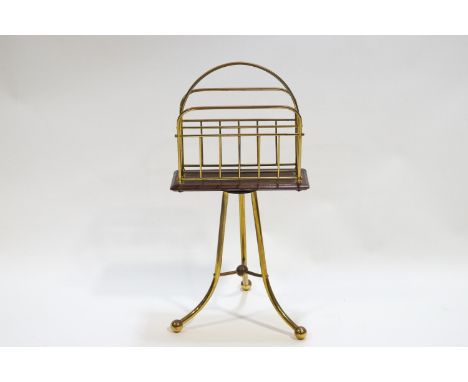 A mahogany and brass double section magazine rack raised on a tripod base, 70cm high