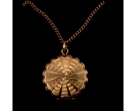 A 9 carat yellow gold circular locket, 20mm engine turned star burst design with scalloped edge, Birmingham 1966, on a yellow