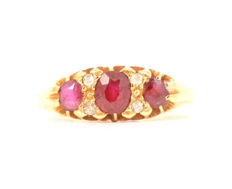 A ruby and diamond half hoop ring, the three oval mixed cut rubies claw set and spaced by two pairs of two small diamonds set