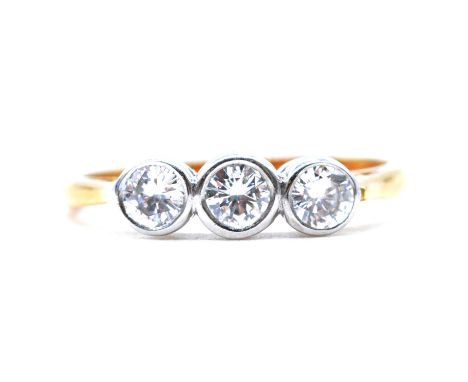 A diamond three stone ring, the three brilliant cut stones collet set in an 18 carat yellow and white gold mount ring size K,