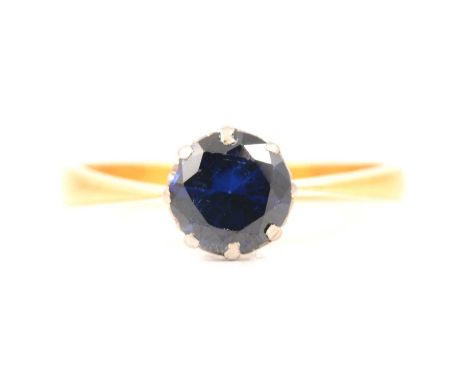 A synthetic sapphire solitaire ring, the brilliant cut stone, 7mm diameter, claw set in a yellow and white metal mount ring s