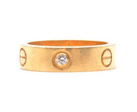 Cartier - a diamond set Love Ring, the 5.5mm wide yellow metal band set with three collet set brilliant cut diamonds, signed 