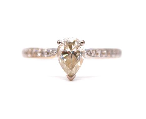 A diamond solitaire ring, the pear shaped stone claw set in an all white metal mount ring size O, eight brilliant cut diamond