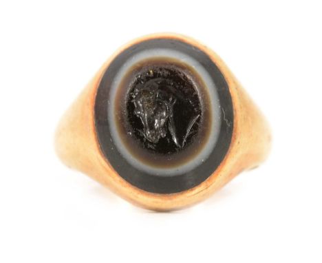 A signet ring with intaglio carved banded agate, the 15x12mm stone carved with a horse's head, plain polished mount, ring siz