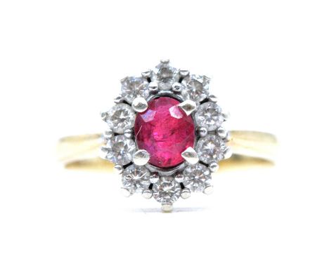 A ruby and diamond cluster ring, the oval mixed cut ruby, approximately 5.6x4.8mm, claw set and surrounded by ten brilliant c