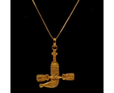 A yellow metal jambiya pendant on a yellow metal chain, a yellow metal jambiya pendant, indistinct hallmarks to back, on a ye