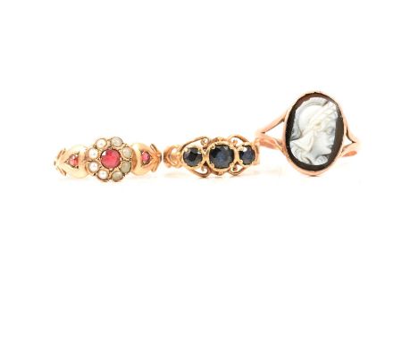 Three Edwardian and later dress rings, a 9 carat yellow gold circular cluster ring set with seed pearls and three red stones,