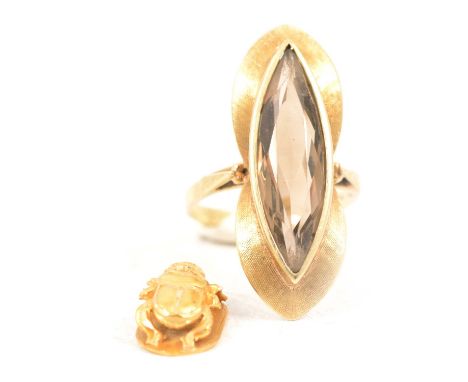 A smoky quartz dress ring and scarab charm, a smoky quartz dress ring, the 23mm marquise cut stone collet set in a yellow met