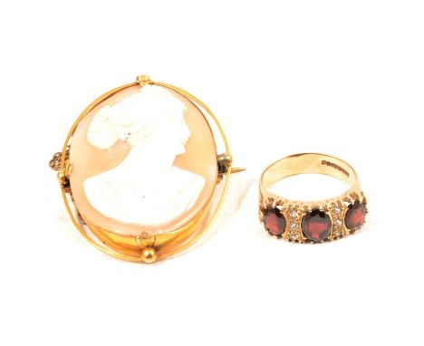 A carved shell cameo brooch and garnet ring, an oval carved shell cameo, 40x30mm, female profile facing right in a yellow met