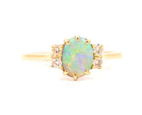 An opal and diamond dress ring, the oval cabochon cut opal with two brilliant cut diamonds to either side, all claw set in an