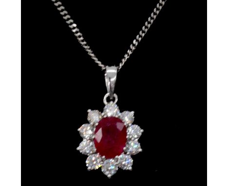 A ruby and diamond cluster pendant and chain, a central oval mixed cut ruby, approximately 8.2x5.5mm, surrounded by ten brill