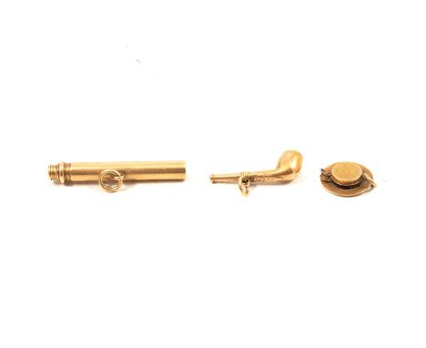 Three charms - a yellow metal whistle in the form of a pipe, 35mm; a 15mm straw hat charm with broken compass inside; a yello