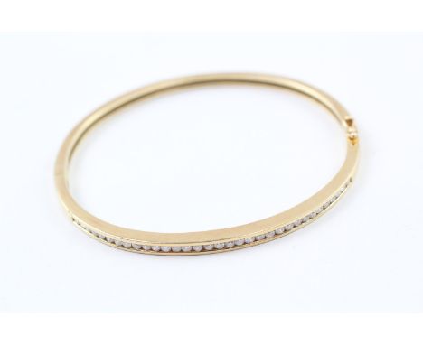 AN 18CT GOLD CHANNEL SET ROUND BRILLIANT DIAMOND SET BANGLE,Weight: 18.7gms