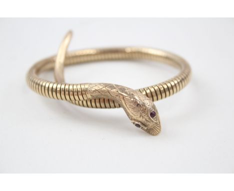 A GOLD FRONTED MID-CENTURY WRAP AROUND SNAKE BANGLE WITH RUBY EYES, Weight: 20gmsMarked 'C&F' '9' 'Steel spring'. 