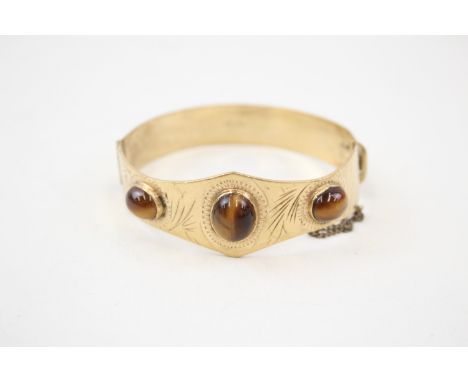 A MID-CENTURY ROLLED GOLD BANGLE SET WITH TIGERS EYE,Weight: 23gms