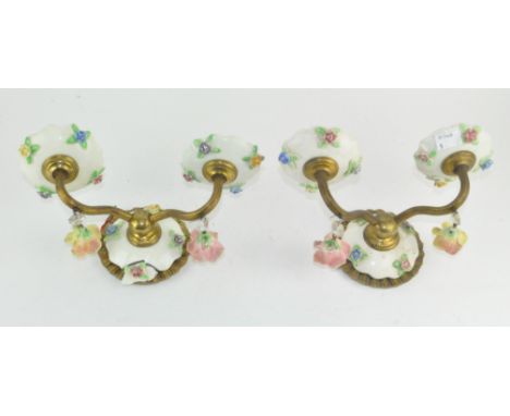 A pair of unusual ceramic wall sconces, adorned with floral decoration, 24cm wide