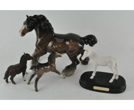 A group of four ceramic horses, including Beswick Shire horse, Royal Doulton horse and more