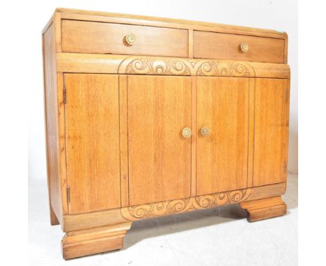 A 1930's Art Deco oak sideboard credenza. Raised on bracket shaped feet with twin door cupboard having short drawers above. T