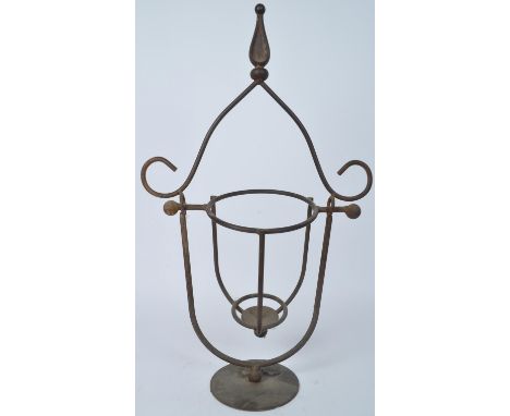 A Victorian 19th century cast metal ecclesiastic swinging candlestick holder having an intricate shaped handle raised on a ro