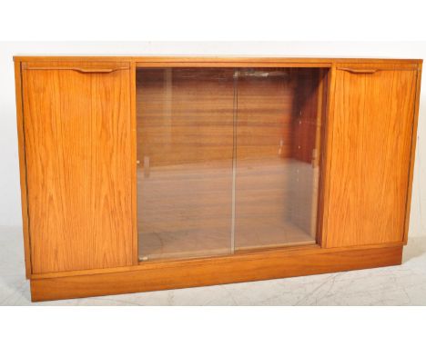 A retro 20th Century Scandinavian teak bookcase / display cabinet having two central sliding glass doors housing a single adj