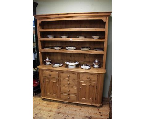 Pine dresser having shelf back above a base of six drawers and two cupboard doors