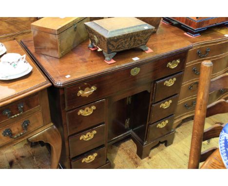 George III mahogany seven drawer kneehole desk having a recessed cupboard and on bracket feet