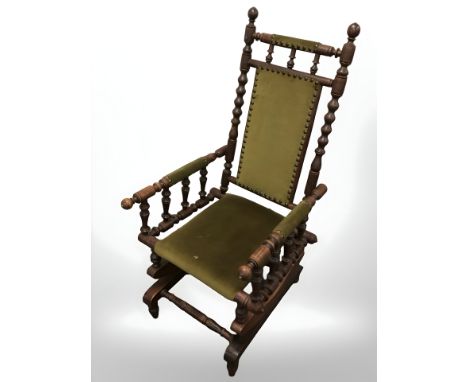 A bobbin turned rocking chair in studded draylon fabric.