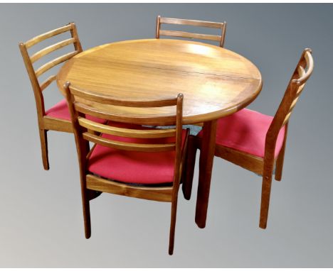 A 20th century teak circular extending dining table and four ladder backed chairs 