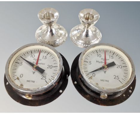 A pair of sterling silver candlesticks together with two hydrometer gauges.