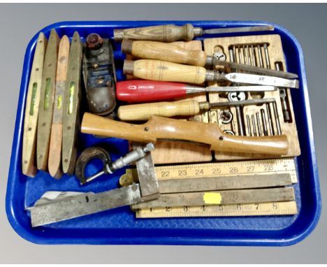 A tray containing folding wooden rulers, chisels, woodworking tools, brass mounted levels, Record plane, pocket knife etc.