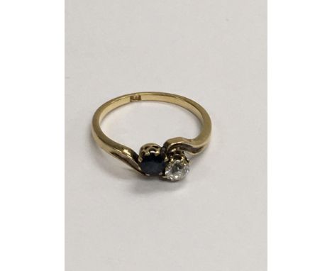 A 18 ct gold diamond and sapphire cross over ring size M.