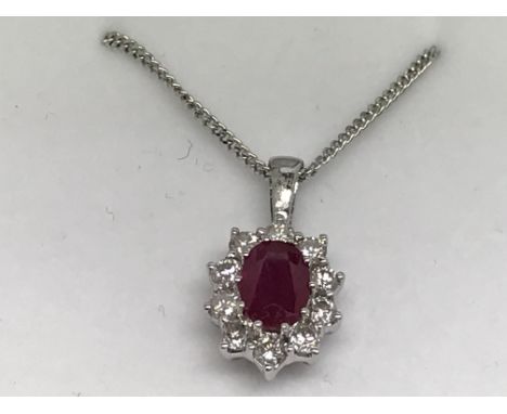 An 18ct white gold oval-cut ruby and RBC diamond cluster pendant on a silver chain. Ruby 1.00ct approx. Diamonds 0.50ct appro