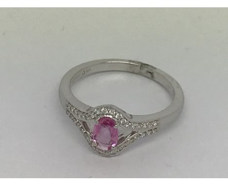 An 18ct white gold oval-cut pink sapphire 0.51ct. Diamonds 0.17ct. Ring size N