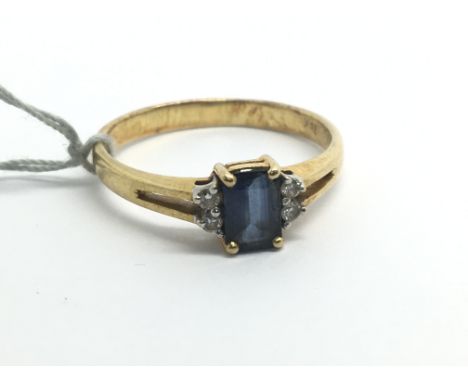 An 18ct yellow gold ring with central emerald cut sapphire and four diamonds, weight approx 3g, ring size approx P