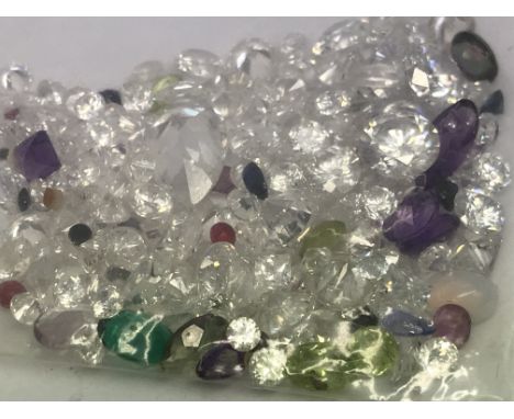 A bag of loose mixed stones including cubic zirconia, emerald, amethyst, peridot, sapphire and ruby, 90.40ct