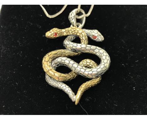 A silver and silver gilt entwined snake pendant with ruby set eyes.