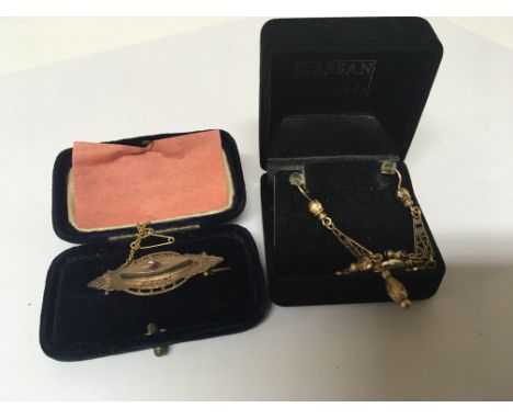 A 9carat gold brooch set with a ruby and a pair of drop earrings. (2)