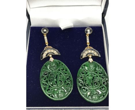 A pair of oval shaped patterned jade drop earrings set with diamonds and inlaid with black enamel, with butterfly backs. Boxe