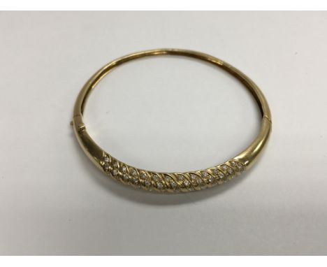 A 18 ct gold bangle inset with numerous diamonds (one missing )