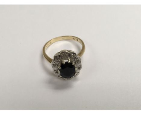 A 9 ct gold ring inset with a central sapphire surrounded by diamond chips size L