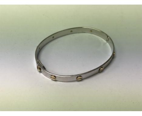 A 9ct white and yellow gold Cartier style bangle. (Approx 21g)