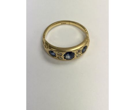 A gold ring inset with three sapphires and four diamonds . Size L