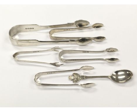 A group of five silver sugar tongs of various sizes and design together with a small silver spoon