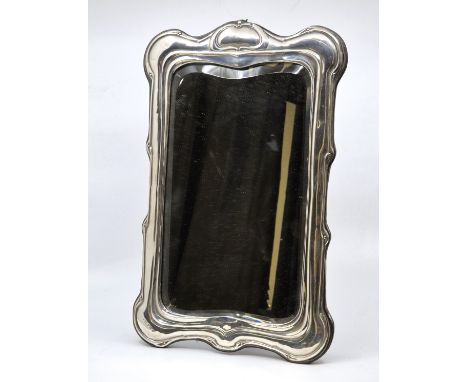 An Art Nouveau silver easel back table mirror, by Henry Matthews, Birmingham 1907, with shaped bevelled plate, height 36cm.  