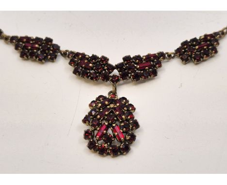 A yellow metal and red paste pendant choker necklace,&nbsp;the front with three shaped links set numerous round cut and bague