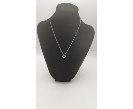 An 18ct white gold pendant set with a cushion cut peridot, surrounded by diamonds on an 18ct gold necklace, total weight 5.1g