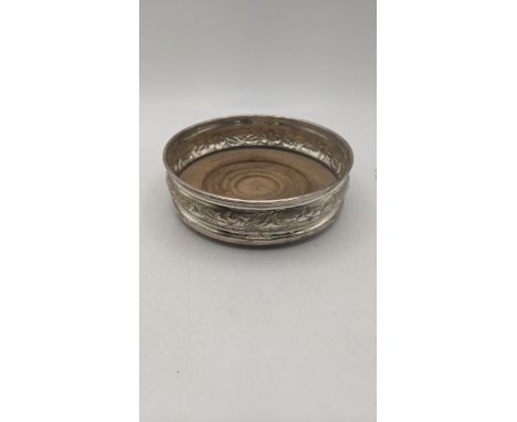 A silver wine coaster with floral embossed and engraved decoration, hallmarked 1966Location:If there is no condition report, 