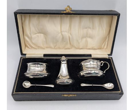 A silver three piece condiment set to include a pepper pot, salts, with glass liner and lidded mustard pot with glass liner, 